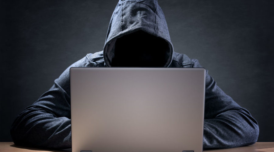 Computer hacker stealing data from a laptop